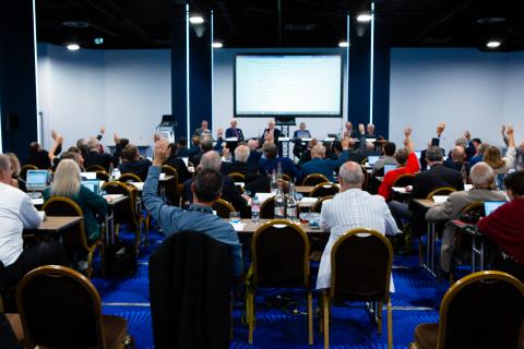 Members of a committee voting by raising their hands.